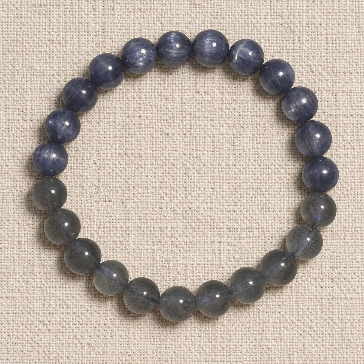Dusk Meridian kyanite and grey moonstone bracelet arranged on neutral woven fabric