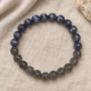 Dusk Meridian blue and grey stone bracelet on draped linen beside pale stone