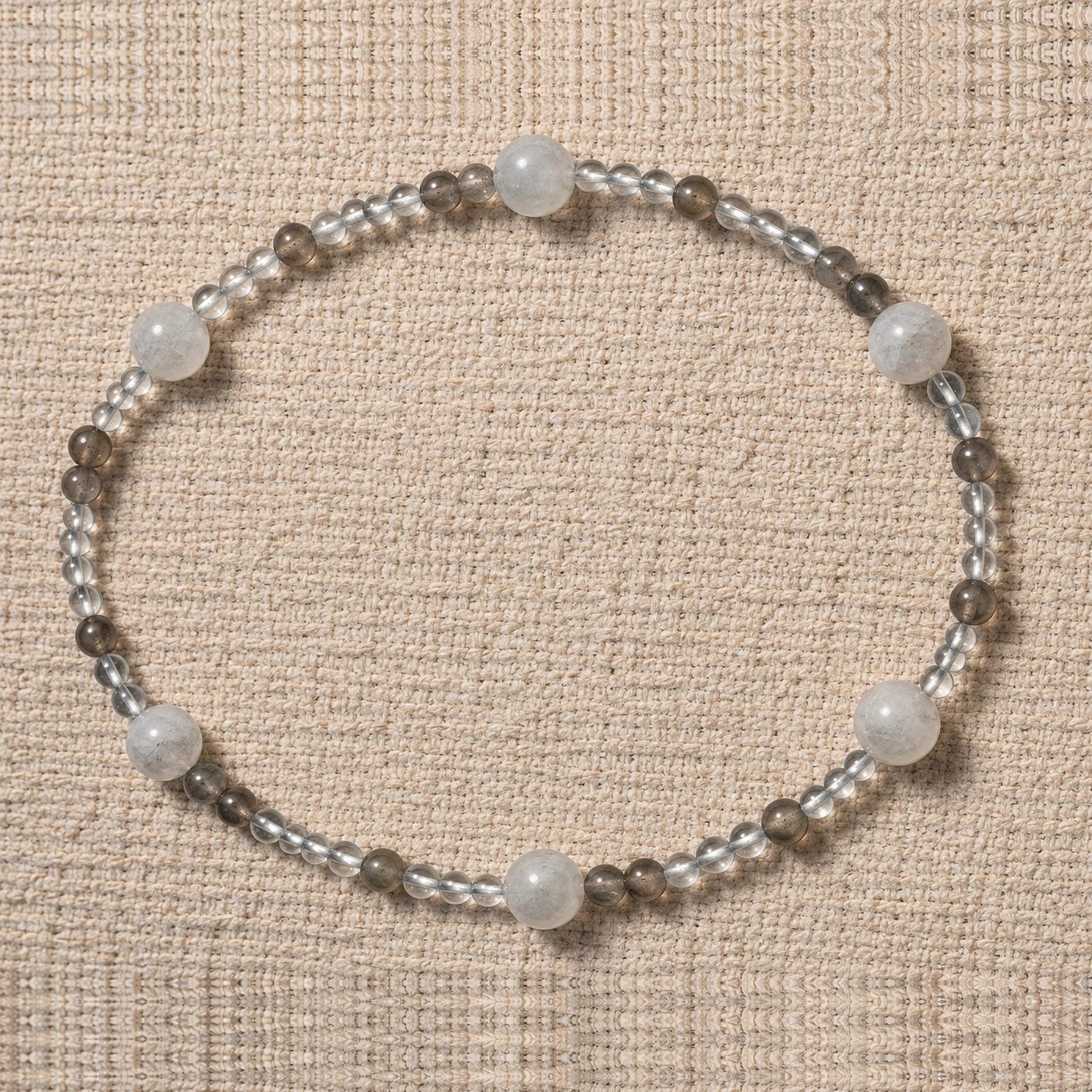 Quiet Orbit quartz and blue moonstone bracelet in a horizontal oval on linen