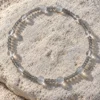 Quiet Orbit quartz and blue moonstone bracelet arranged on a sunlit pale rock
